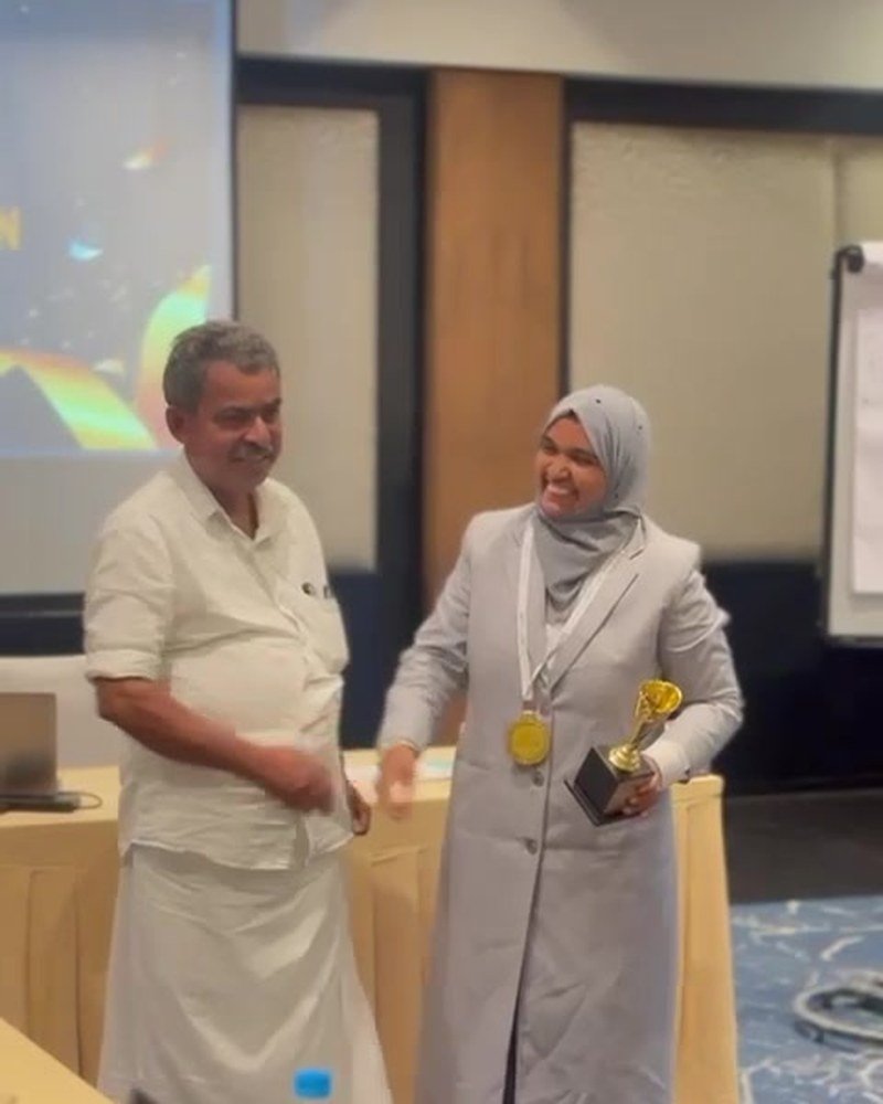 Rabeeba Vellangara receiving a trophy at an awards ceremony